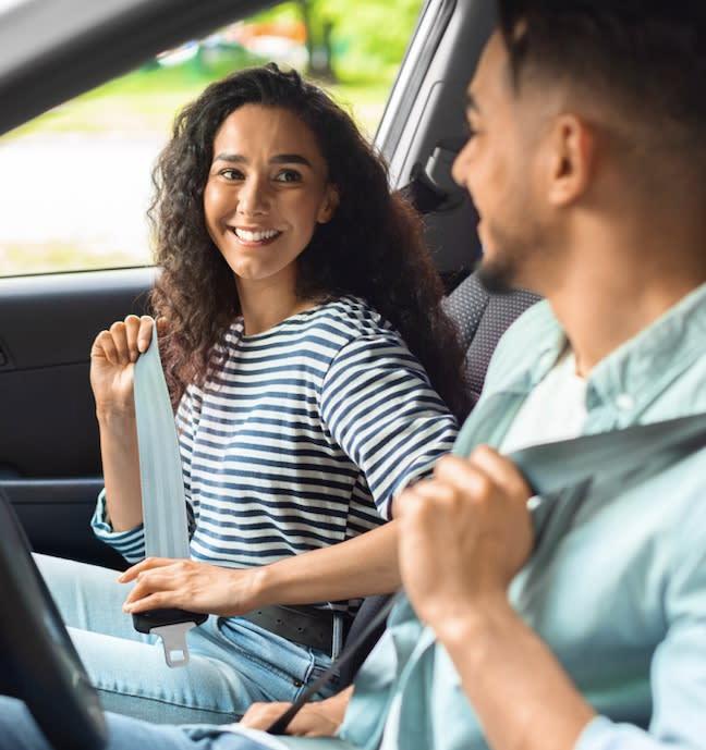 Couple securing their seat belts in a car