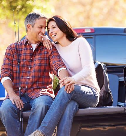 A couple sitting in front of their own truck