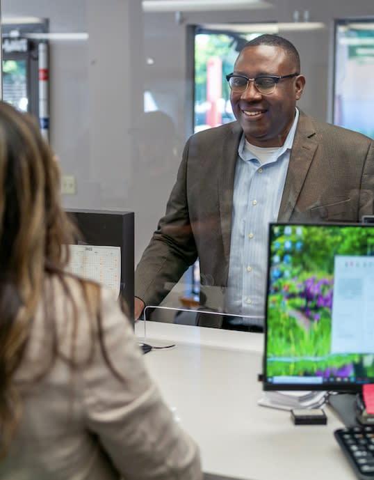 Bank worker providing a consultation to a visitor about checking accounts
