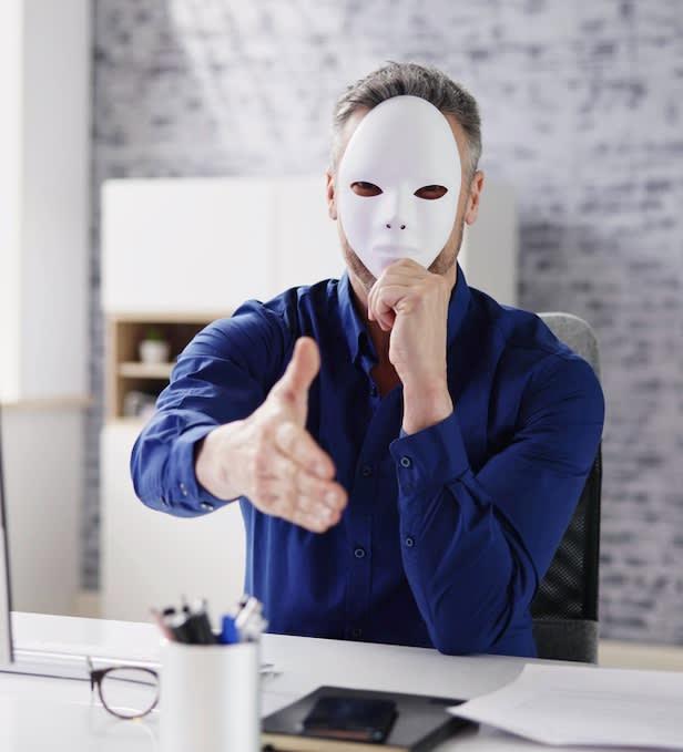 A scam car dealer with a mask covering his face